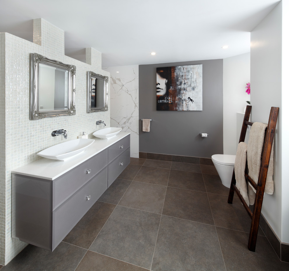 Inspiration for a large modern master bathroom in Sydney with flat-panel cabinets, grey cabinets, a one-piece toilet, a vessel sink, solid surface benchtops and grey floor.