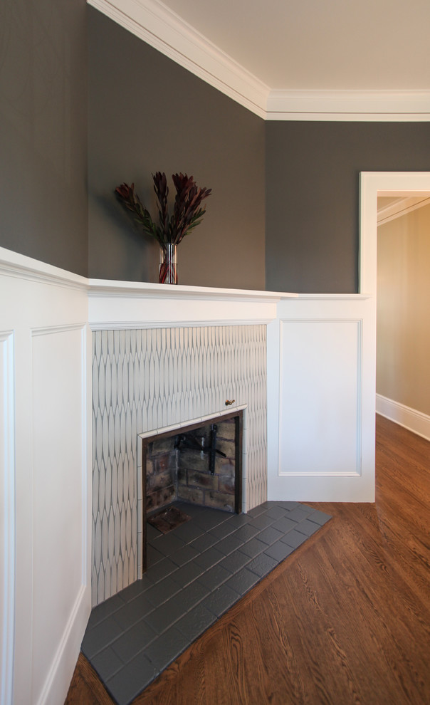 Mid-sized traditional separate dining room in Minneapolis with grey walls, medium hardwood floors, a corner fireplace, a tile fireplace surround and brown floor.