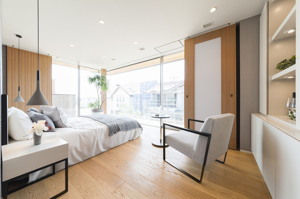 На фото: спальня в стиле модернизм с белыми стенами и светлым паркетным полом без камина с