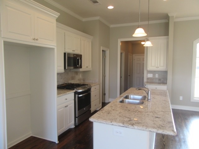Eat-in kitchen - mid-sized transitional dark wood floor eat-in kitchen idea in Jackson with an undermount sink, raised-panel cabinets, white cabinets, granite countertops, ceramic backsplash, stainless steel appliances and an island