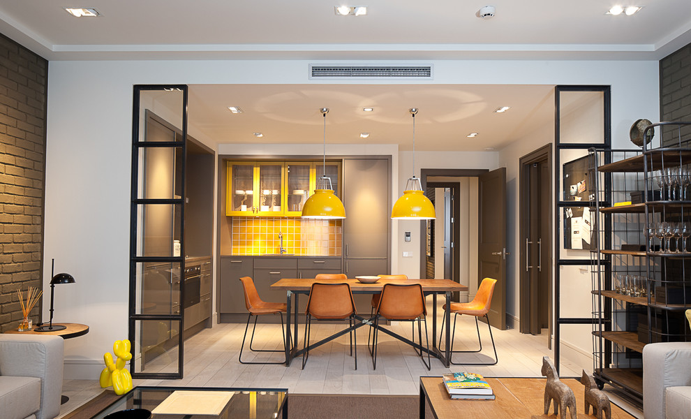 This is an example of a mid-sized contemporary l-shaped eat-in kitchen in Barcelona with flat-panel cabinets, grey cabinets, yellow splashback, ceramic splashback, light hardwood floors and no island.