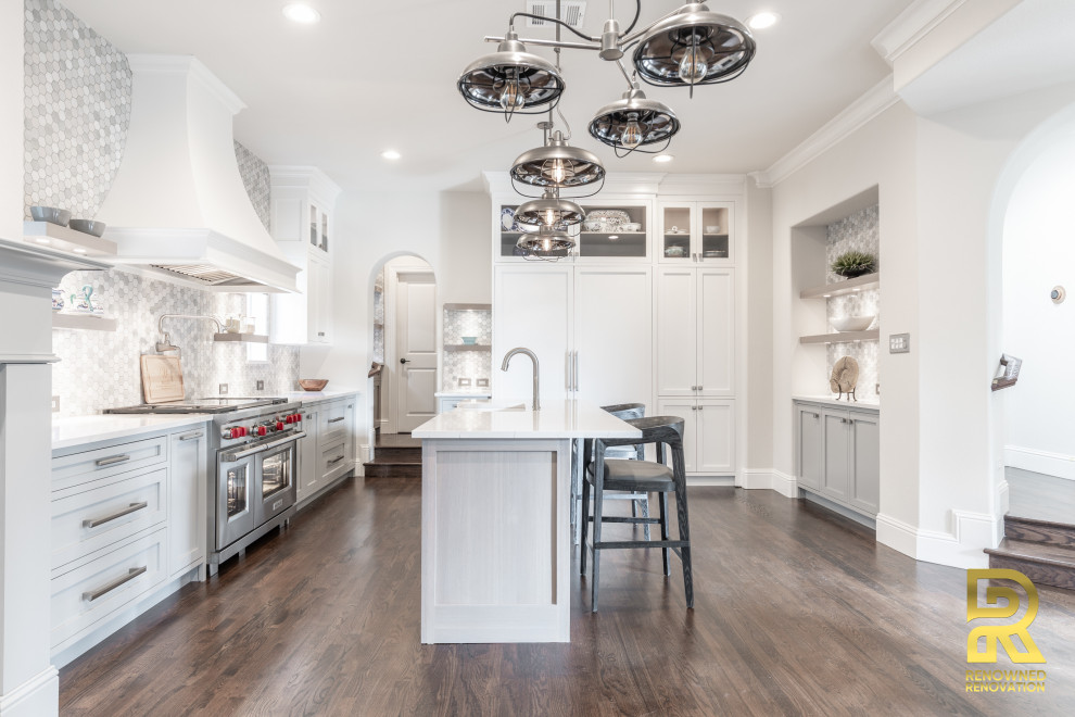 Photo of a large traditional galley kitchen/diner in Dallas with a submerged sink, shaker cabinets, white cabinets, engineered stone countertops, white splashback, porcelain splashback, stainless steel appliances, medium hardwood flooring, an island, multi-coloured floors and white worktops.