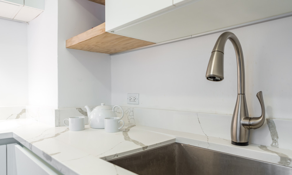 Example of a mid-sized transitional l-shaped light wood floor enclosed kitchen design in Chicago with an undermount sink, flat-panel cabinets, white cabinets, marble countertops, white backsplash, subway tile backsplash, stainless steel appliances, no island and white countertops