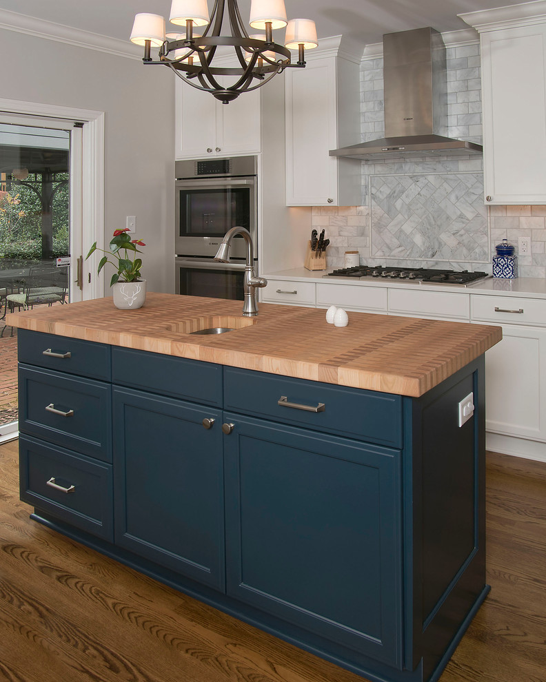 Inspiration for a mid-sized transitional u-shaped medium tone wood floor and brown floor eat-in kitchen remodel with an undermount sink, recessed-panel cabinets, white cabinets, quartz countertops, gray backsplash, marble backsplash, stainless steel appliances and an island