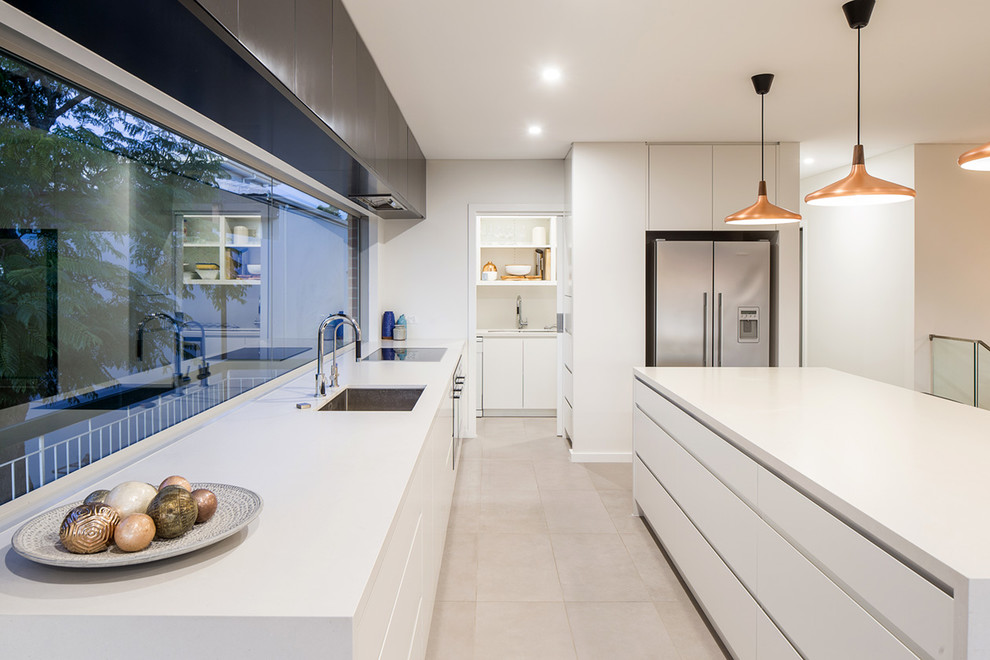Design ideas for an expansive modern galley eat-in kitchen in Sydney with a single-bowl sink, flat-panel cabinets, white cabinets, granite benchtops, stainless steel appliances, ceramic floors and with island.