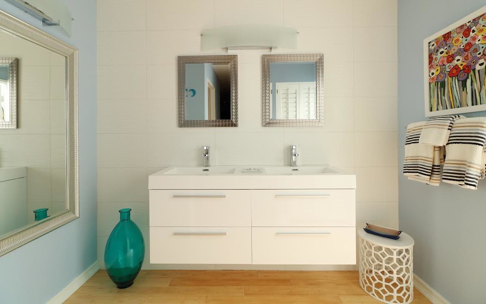 Design ideas for a mid-sized modern master bathroom in Other with flat-panel cabinets, white cabinets, white tile, porcelain tile, grey walls, light hardwood floors, an integrated sink, engineered quartz benchtops, beige floor and white benchtops.
