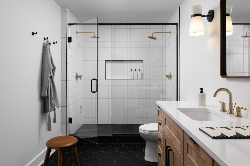 Photo of a large scandi ensuite bathroom in Detroit with shaker cabinets, light wood cabinets, a double shower, a one-piece toilet, black and white tiles, ceramic tiles, white walls, ceramic flooring, a submerged sink, engineered stone worktops, black floors, a hinged door, white worktops, a wall niche, double sinks and a built in vanity unit.