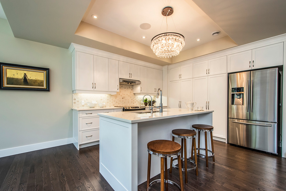 Inspiration for a mid-sized transitional l-shaped dark wood floor and brown floor open concept kitchen remodel with a double-bowl sink, shaker cabinets, white cabinets, quartzite countertops, stainless steel appliances, an island, white backsplash and mosaic tile backsplash