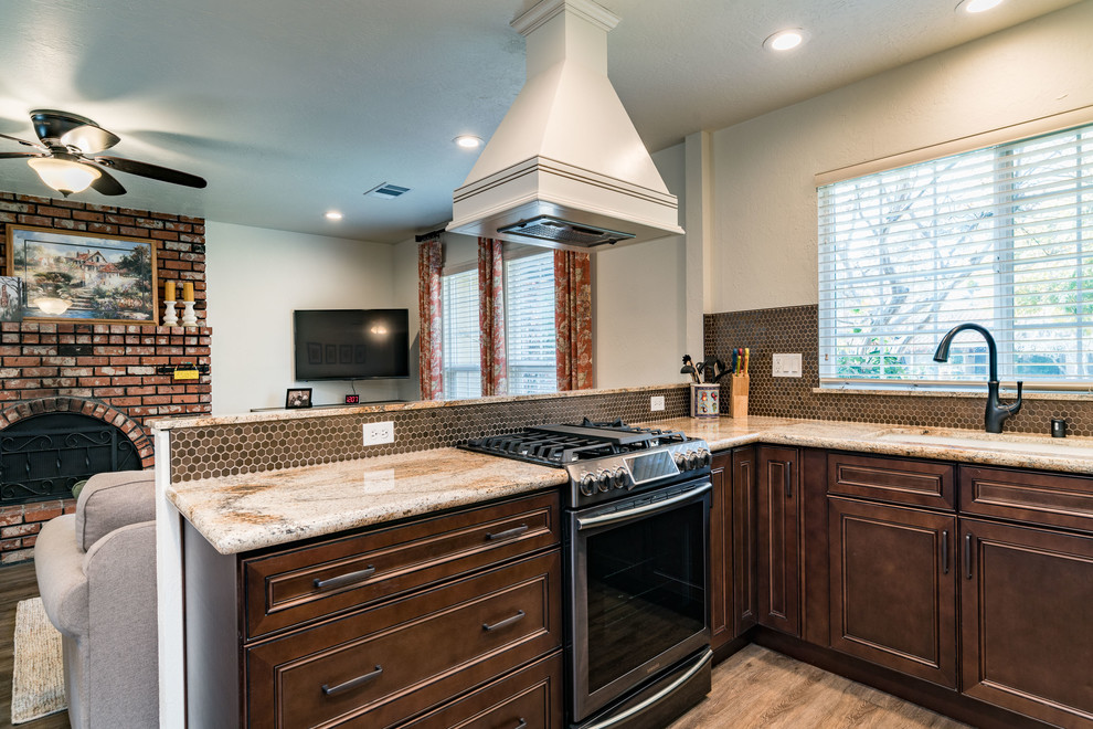 Inspiration for a mid-sized transitional u-shaped medium tone wood floor and brown floor eat-in kitchen remodel with an undermount sink, recessed-panel cabinets, white cabinets, granite countertops, brown backsplash, mosaic tile backsplash, stainless steel appliances and no island