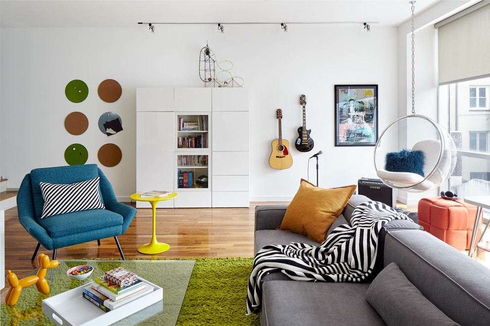 This is an example of a large contemporary gender-neutral kids' room in Philadelphia with white walls and light hardwood floors.