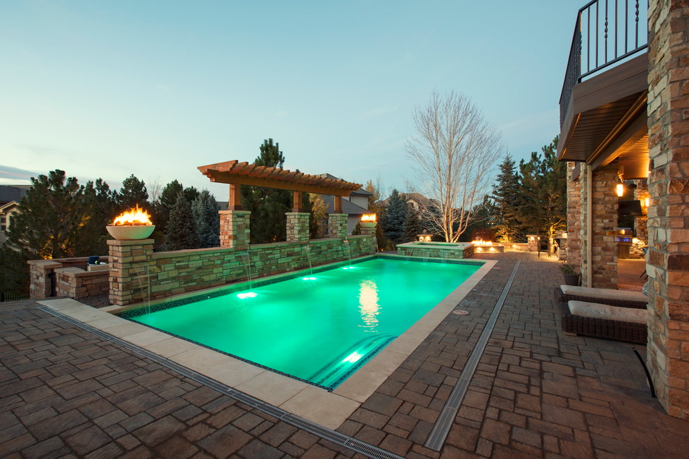 Mid-sized mountain style backyard stone and rectangular pool photo in Denver