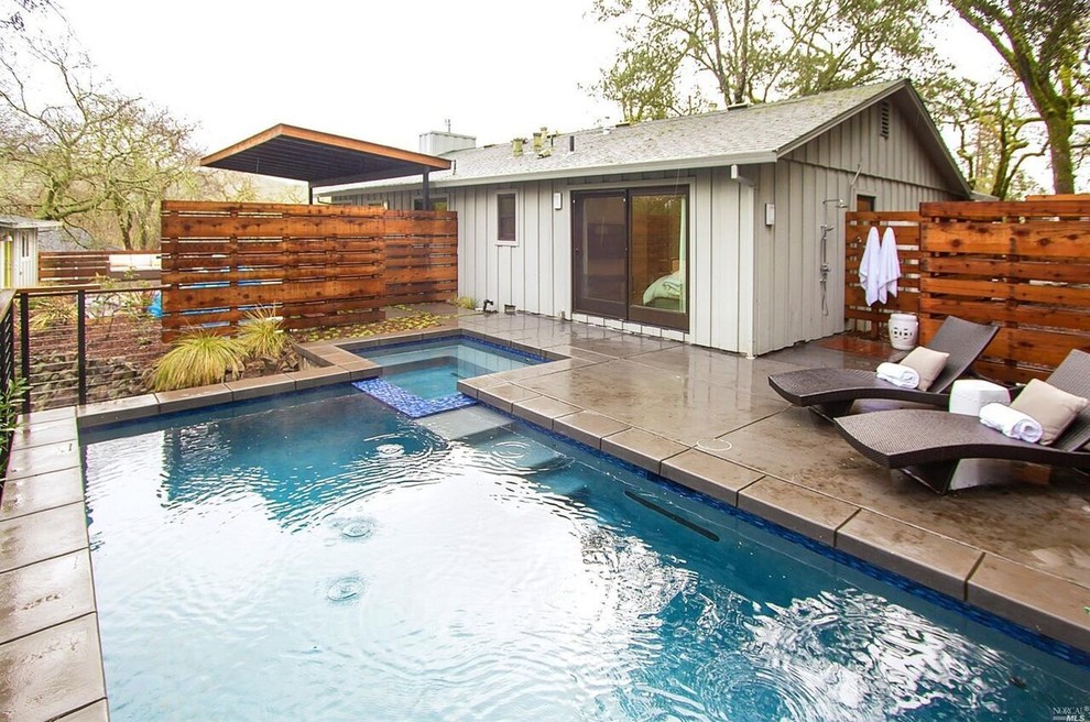 This is an example of a mid-sized modern backyard rectangular lap pool in San Francisco with concrete pavers.
