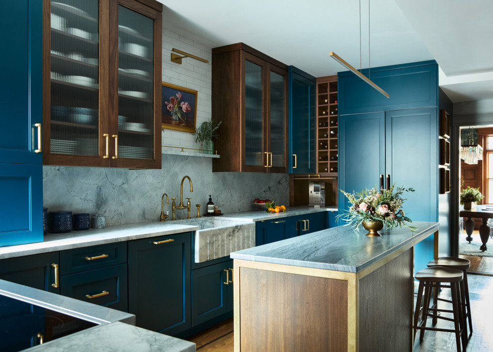 Example of a mid-sized transitional single-wall enclosed kitchen design in Boston with a farmhouse sink, recessed-panel cabinets, blue cabinets, quartzite countertops, gray backsplash, stone slab backsplash, paneled appliances, an island and gray countertops