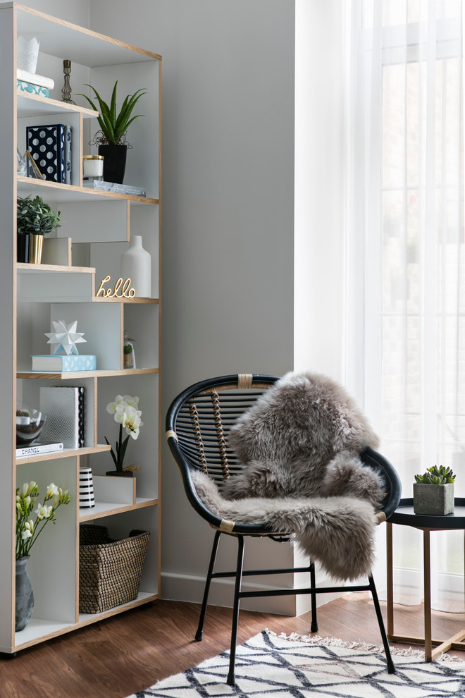 This is an example of a scandinavian living room in London with grey walls and medium hardwood floors.