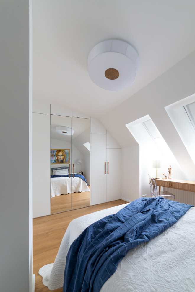 Ispirazione per una piccola camera degli ospiti minimalista con pareti bianche, parquet chiaro e pavimento beige