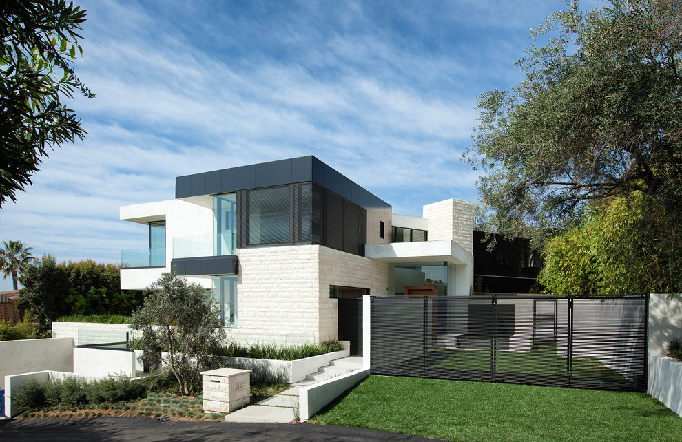 This is an example of a contemporary two-storey white exterior in Los Angeles with stone veneer and a flat roof.