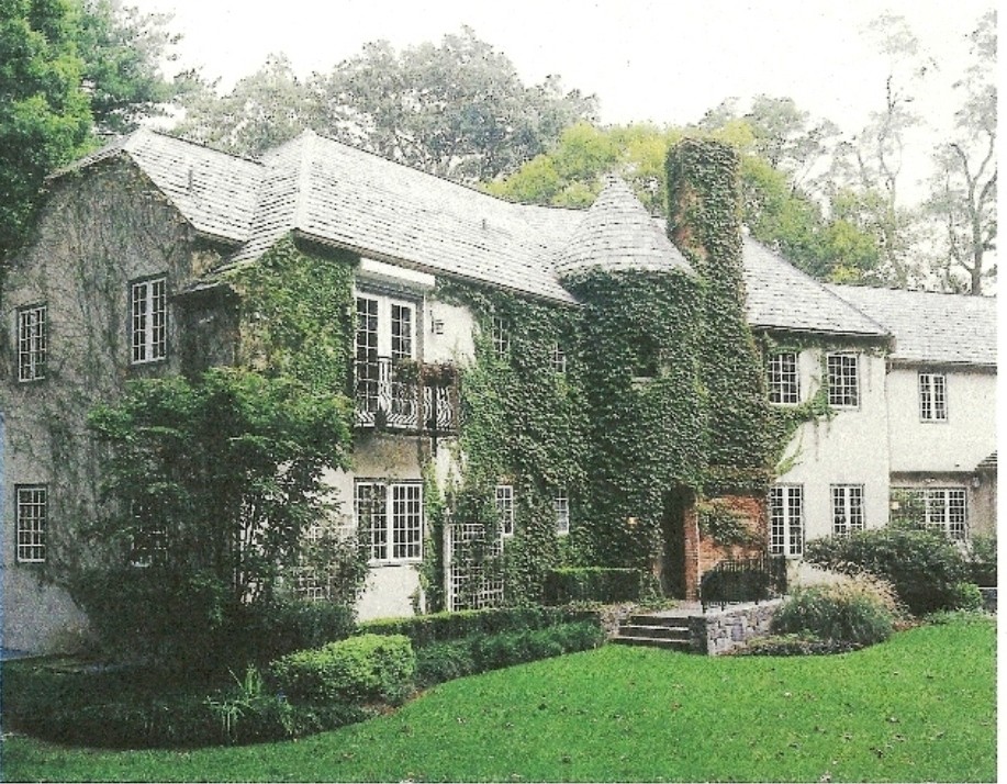 This is an example of an expansive traditional two-storey stucco beige exterior in New York with a clipped gable roof.