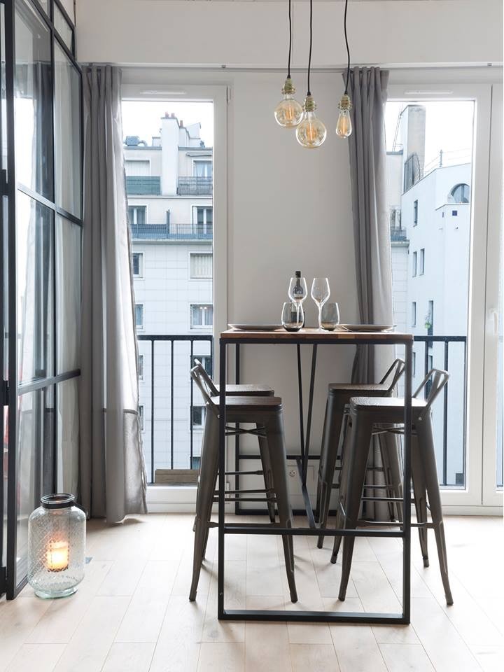 Design ideas for a small industrial open plan dining in Paris with grey walls and light hardwood floors.