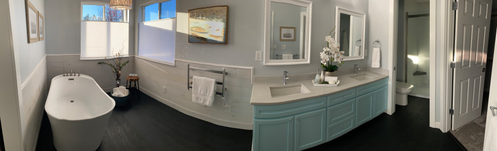 Photo of a mid-sized contemporary master bathroom in Other with shaker cabinets, turquoise cabinets, a freestanding tub, an alcove shower, a two-piece toilet, white tile, grey walls, vinyl floors, an undermount sink, quartzite benchtops, black floor, a sliding shower screen, white benchtops, an enclosed toilet, a double vanity, a freestanding vanity and wood walls.