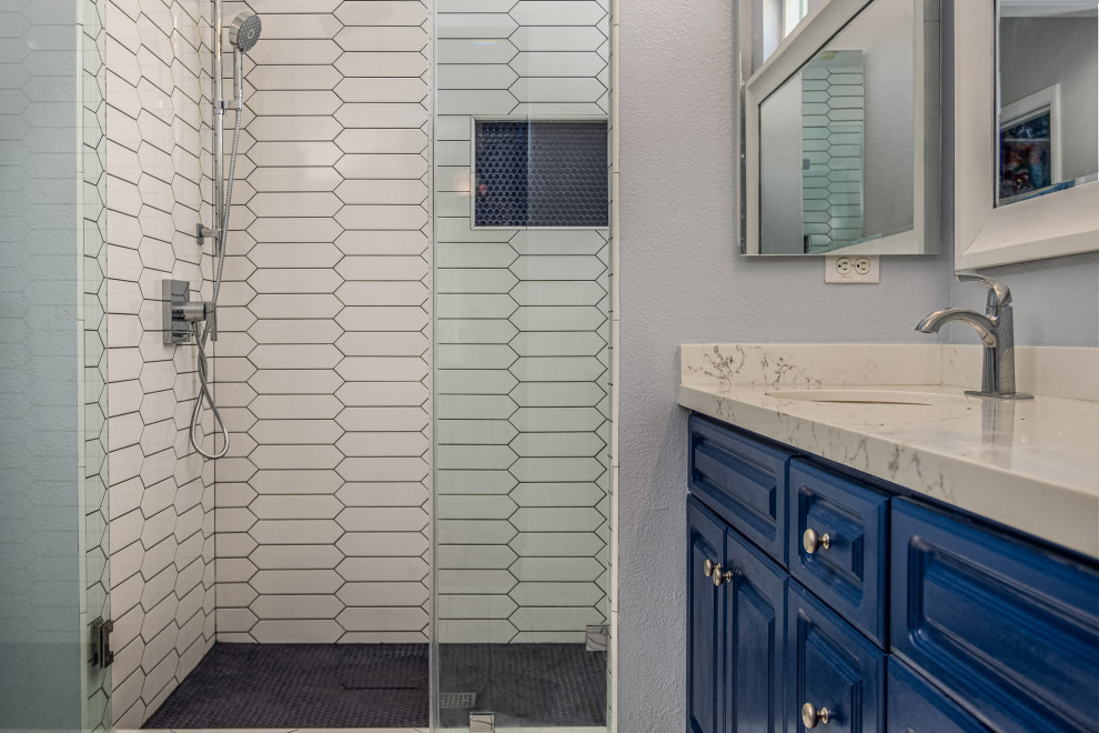 Inspiration för mellanstora moderna grått en-suite badrum, med skåp i shakerstil, blå skåp, en hörndusch, vit kakel, porslinskakel, blå väggar, klinkergolv i porslin, ett undermonterad handfat, bänkskiva i kvarts, vitt golv och dusch med gångjärnsdörr