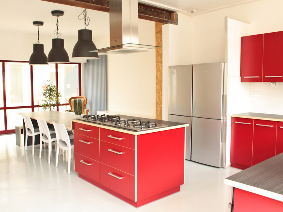 Design ideas for a large industrial l-shaped open plan kitchen in Other with a drop-in sink, red cabinets, laminate benchtops, white splashback, stainless steel appliances, concrete floors, with island, grey floor and grey benchtop.