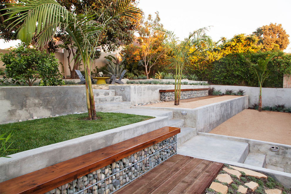 Contemporary backyard partial sun garden in Los Angeles with a retaining wall and gravel.