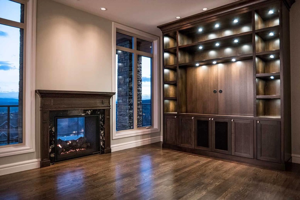Example of a transitional dark wood floor and brown floor home design design in Calgary with gray walls, a two-sided fireplace, a tile fireplace and a media wall