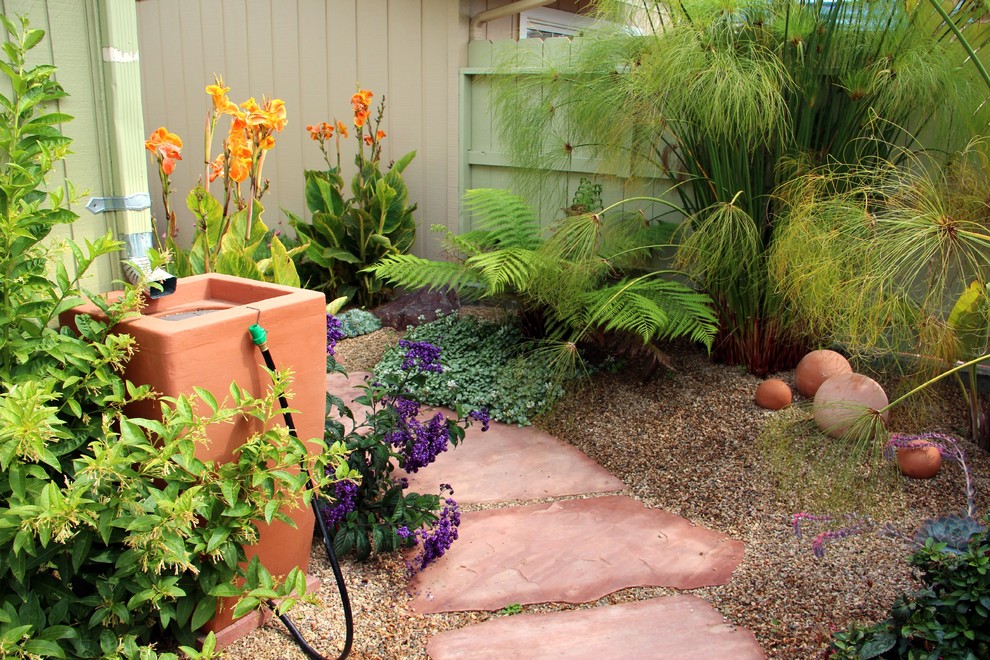 Inspiration for a mid-sized mediterranean backyard partial sun xeriscape in San Luis Obispo with a water feature and natural stone pavers.