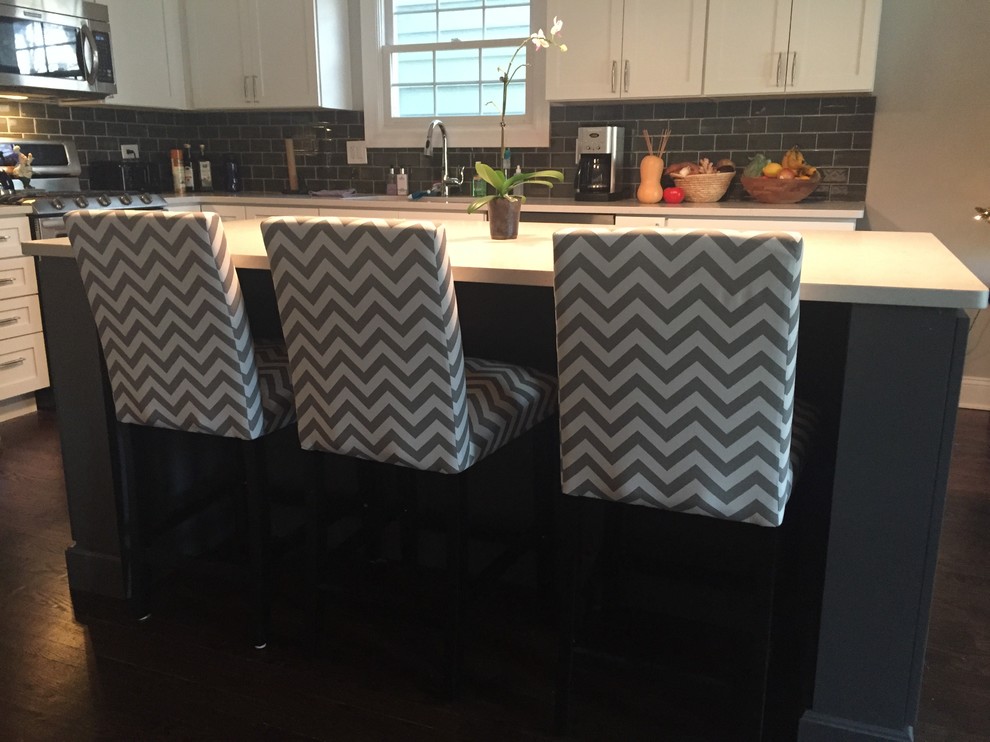 Transitional l-shaped kitchen photo in Chicago with an undermount sink, shaker cabinets, white cabinets, quartz countertops, gray backsplash, subway tile backsplash, stainless steel appliances and an island