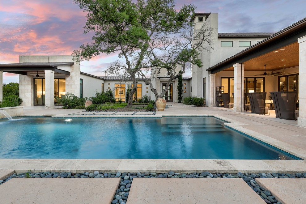 Inspiration for a contemporary backyard rectangular lap pool in Austin with a water feature and concrete slab.