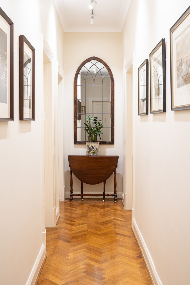 Mid-sized traditional hallway in Sydney with beige walls, light hardwood floors and brown floor.