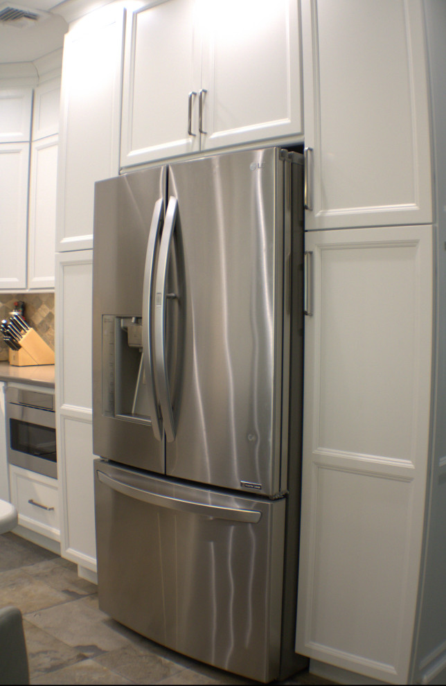 Eat-in kitchen - transitional l-shaped eat-in kitchen idea with white cabinets, multicolored backsplash, an island and white countertops