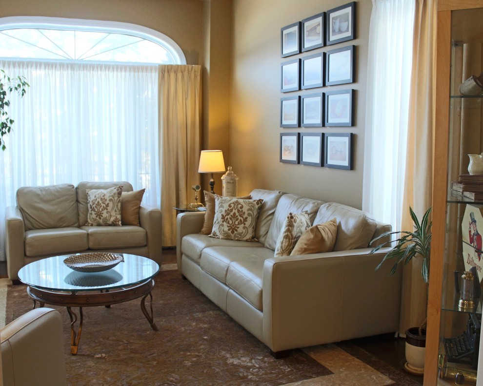 Photo of a mid-sized transitional enclosed living room in Toronto with beige walls and dark hardwood floors.