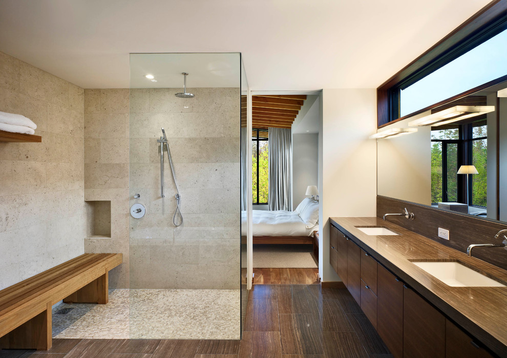 Photo of a large contemporary master bathroom in Toronto with an undermount sink, flat-panel cabinets, dark wood cabinets, limestone benchtops, a curbless shower, beige tile, white walls, limestone floors and limestone.