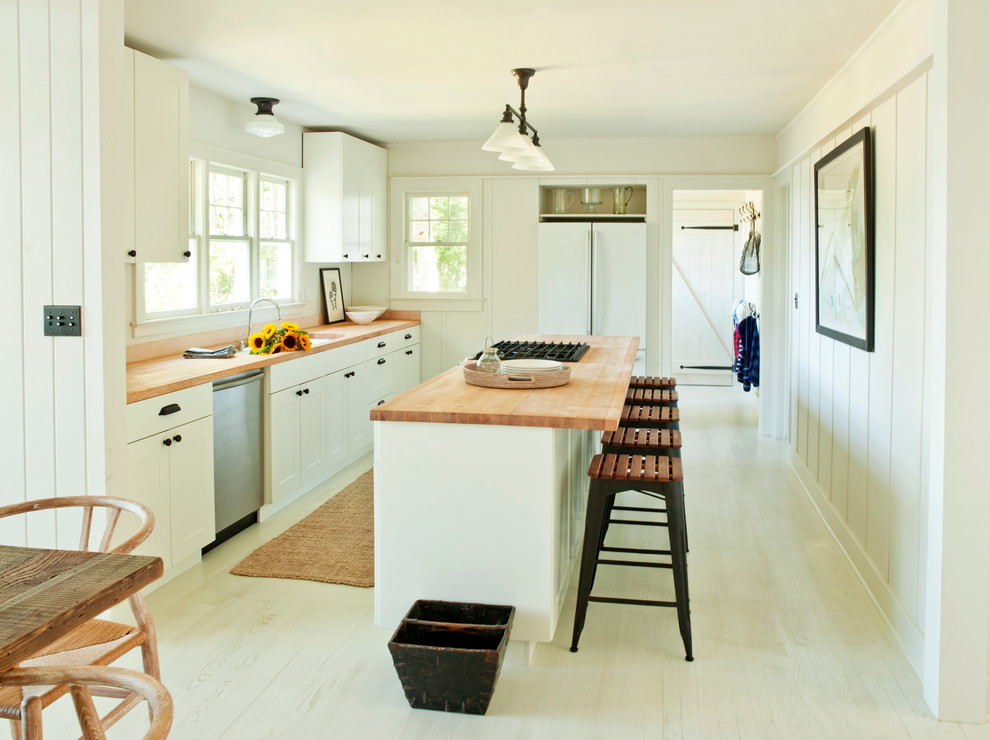 Inspiration for a modern kitchen in New York with white appliances and wood benchtops.