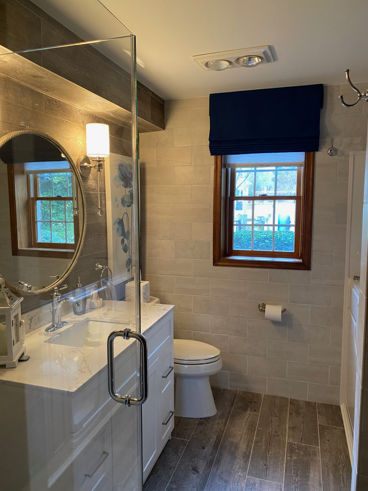 Mid-sized country master bathroom in DC Metro with shaker cabinets, white cabinets, a corner shower, gray tile, porcelain tile, porcelain floors, an undermount sink, engineered quartz benchtops, grey floor, white benchtops, a single vanity, a built-in vanity, wood walls and grey walls.