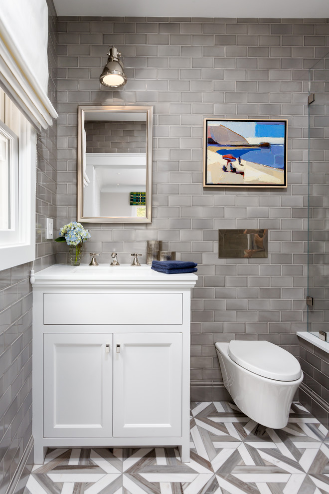 Design ideas for a small transitional kids bathroom in Los Angeles with recessed-panel cabinets, white cabinets, an undermount tub, an alcove shower, a wall-mount toilet, gray tile, mosaic tile, grey walls, mosaic tile floors, an undermount sink and engineered quartz benchtops.