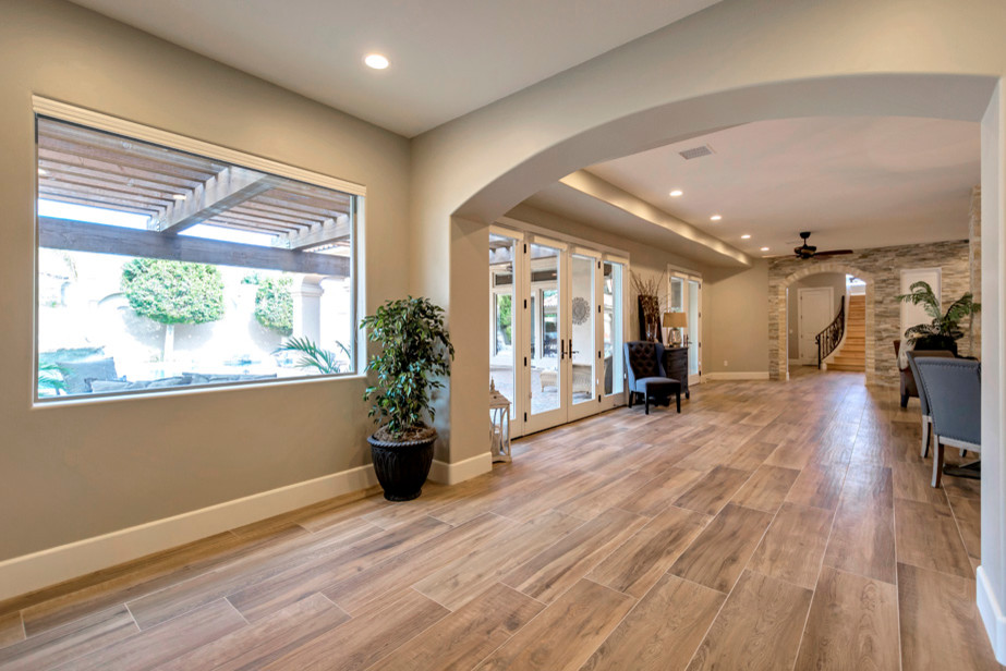 Large transitional porcelain tile and brown floor single front door photo in Phoenix with brown walls and a black front door