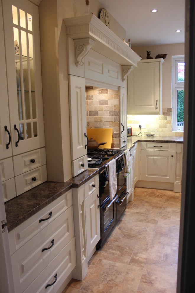 This is an example of a medium sized traditional l-shaped kitchen/diner in Dorset with a built-in sink, raised-panel cabinets, beige cabinets, laminate countertops, orange splashback, mosaic tiled splashback, black appliances, terracotta flooring and no island.