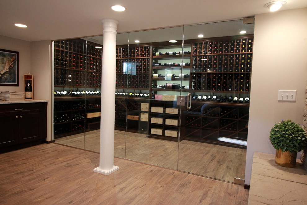 This is an example of a mid-sized traditional wine cellar in Columbus with laminate floors, storage racks and brown floor.