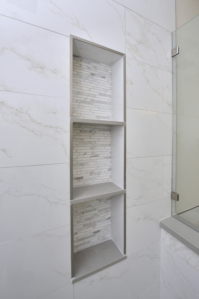 This is an example of a large transitional master bathroom in Phoenix with shaker cabinets, white cabinets, a drop-in tub, an alcove shower, gray tile, white tile, marble, beige walls, porcelain floors, an undermount sink, solid surface benchtops, beige floor and a hinged shower door.
