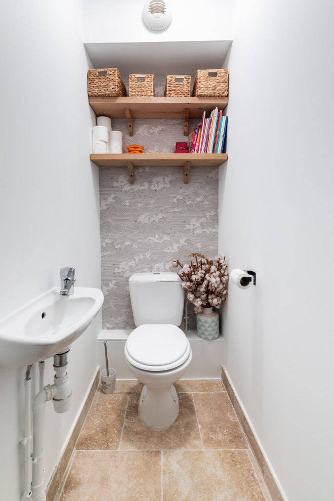 Exempel på ett mellanstort medelhavsstil vit vitt toalett, med en toalettstol med hel cisternkåpa, vita väggar, travertin golv, ett väggmonterat handfat, bänkskiva i kvartsit och beiget golv
