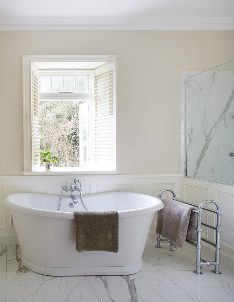 Inspiration for a large traditional master wet room bathroom in Dublin with recessed-panel cabinets, grey cabinets, a freestanding tub, a wall-mount toilet, white tile, porcelain tile, white walls, porcelain floors, an undermount sink and marble benchtops.