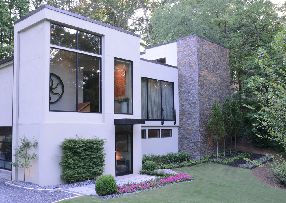 Inspiration for a large modern three-storey stucco grey exterior in Atlanta with a flat roof.