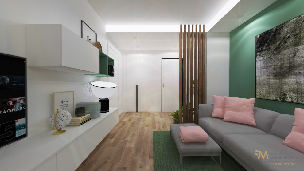 Modern inredning av ett litet separat vardagsrum, med gröna väggar, ljust trägolv, en inbyggd mediavägg och brunt golv