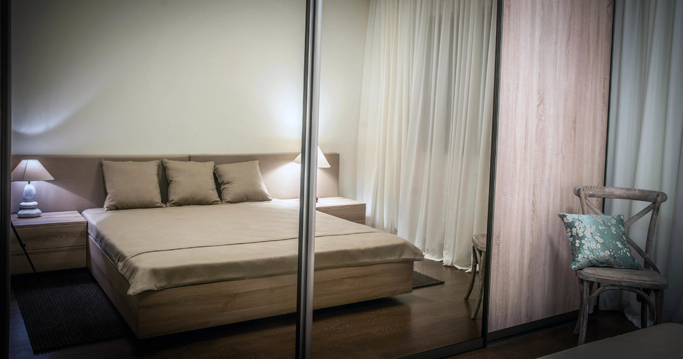 Photo of a mid-sized contemporary guest bedroom in Orlando with beige walls, medium hardwood floors and no fireplace.