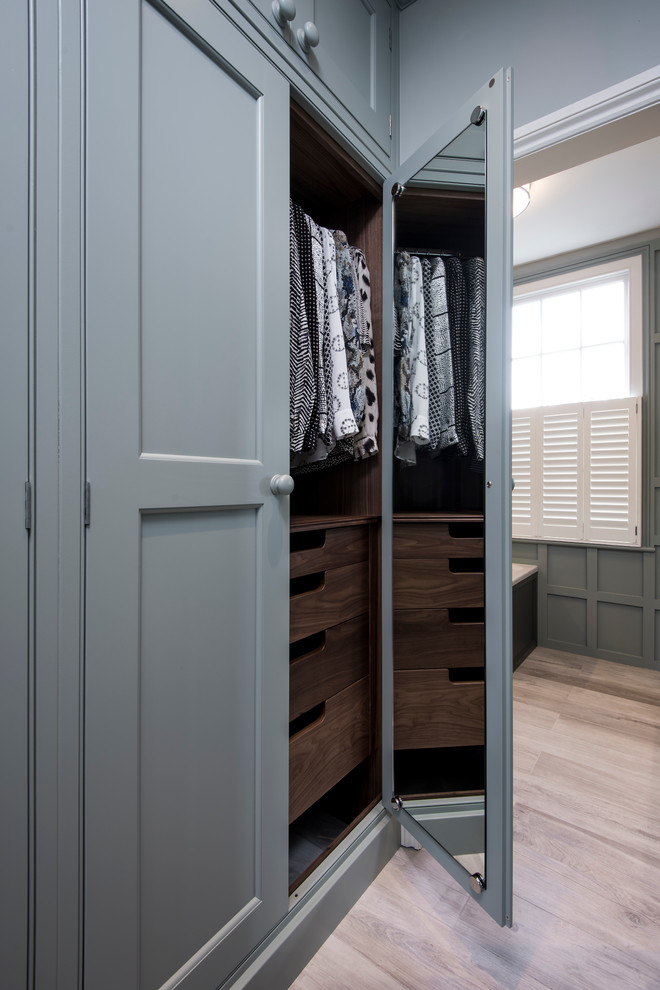 Design ideas for a mid-sized transitional storage and wardrobe in London with carpet.
