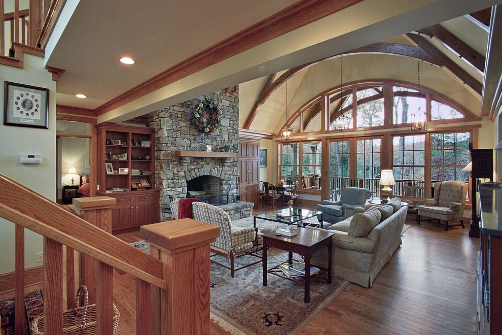 Inspiration for a large country open concept family room in Other with beige walls, light hardwood floors, a standard fireplace and a stone fireplace surround.