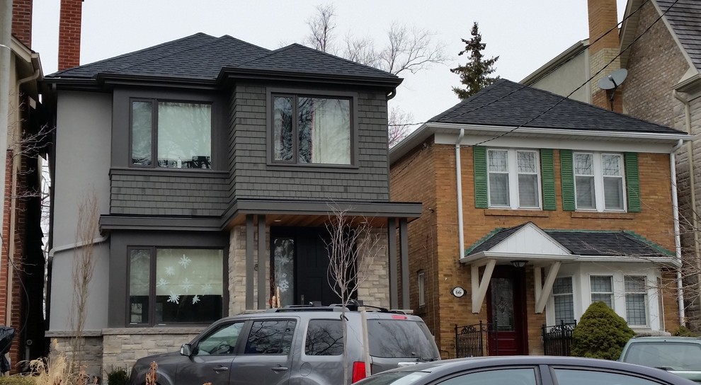 Photo of a transitional two-storey grey exterior in Toronto with wood siding and a hip roof.
