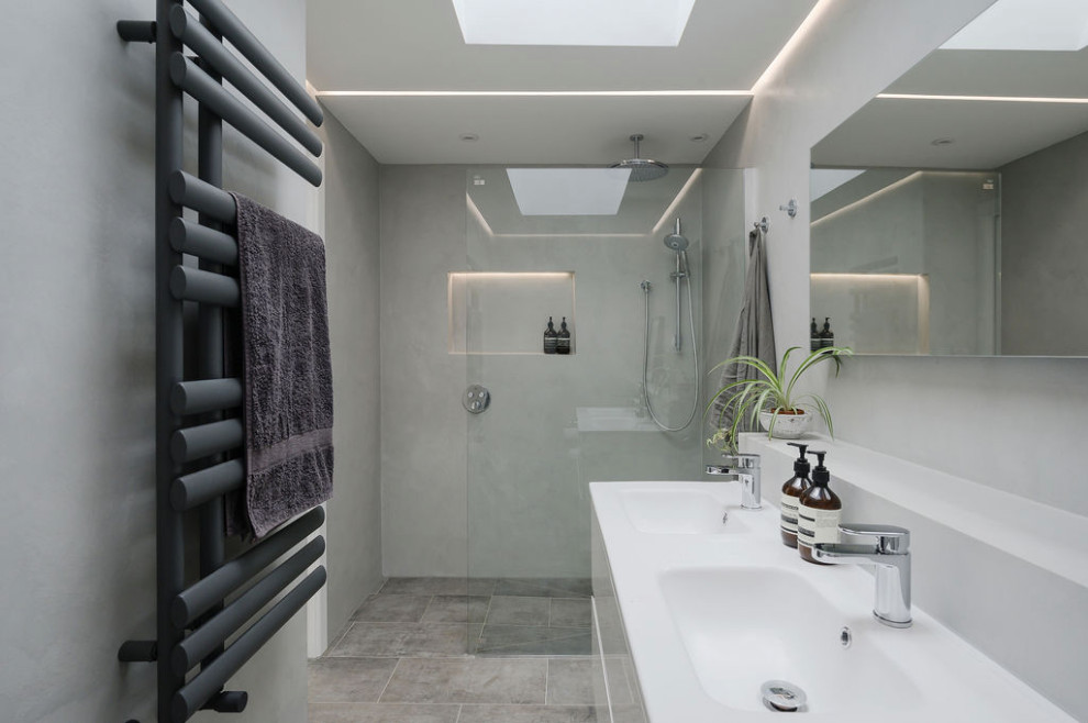 Medium sized contemporary ensuite bathroom in Surrey with flat-panel cabinets, white cabinets, a walk-in shower, a wall mounted toilet, porcelain flooring, a wall-mounted sink, grey floors, an open shower, feature lighting, double sinks, a floating vanity unit and a drop ceiling.